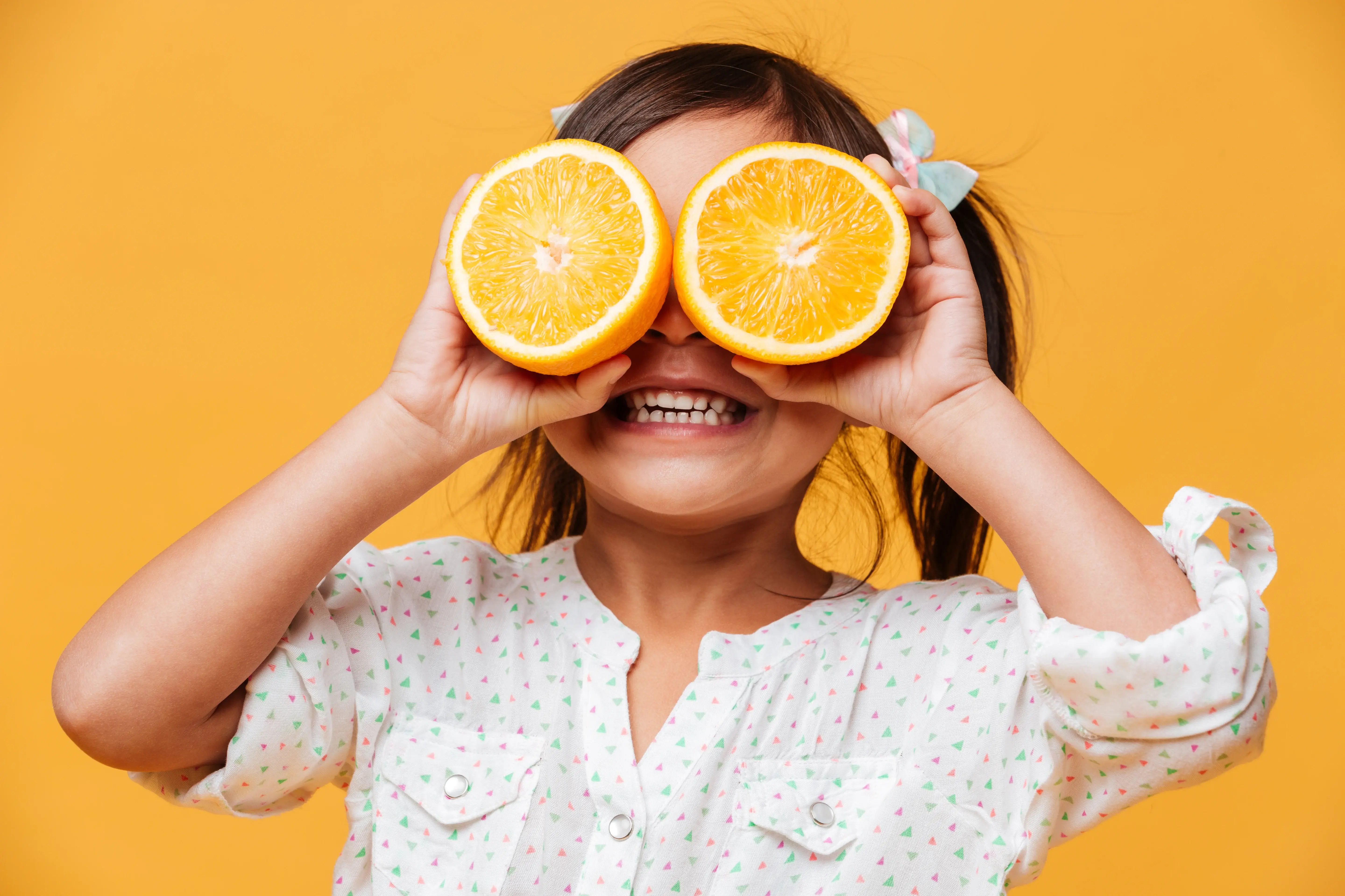 little-girl-child-covering-eyes-with-orange.jpg